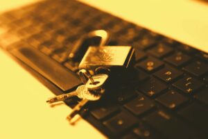 Database locks are represented by keys unlocking a padlock with a computer in the background